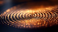 Mesmerizing golden spiral pattern with glowing ripples and concentric circles on dark background creates hypnotic abstract macro composition with bokeh effect.