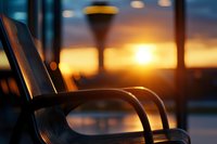 Empty bench at sunset with warm golden light and bokeh effect, urban street lamp silhouette creating peaceful evening atmosphere in public space.