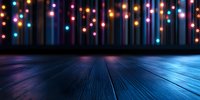 Glowing colorful bokeh lights hanging over dark wooden floor with dramatic blue lighting, creating festive atmosphere for holiday or party background.