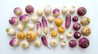Colorful assortment of fresh turnips and radishes in purple, white and yellow varieties arranged on white background for healthy cooking recipes.