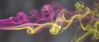 Abstract colorful smoke swirls in pink and yellow hues flowing against dark background for creative design projects and artistic compositions.
