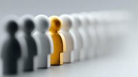 Golden figure standing out among row of black and white wooden pawns on light background, symbolizing leadership, uniqueness, and individuality.