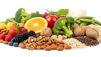 Fresh organic vegetables fruits nuts and seeds arranged on white background for healthy eating diet nutrition wellness lifestyle meal planning.