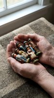Elderly hands holding multiple prescription medication bottles and pills for healthcare and pharmaceutical concepts.