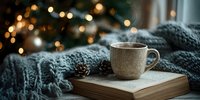 Cozy winter evening with steaming cup on open book, wrapped in knitted gray scarf against blurred Christmas lights background.