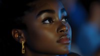Young African American woman with gold earrings looking up thoughtfully in dramatic blue lighting for portraits and lifestyle photography.