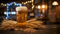 Fresh golden beer with foam head and wheat stalks on wooden table in warm pub atmosphere with bokeh lights creating cozy evening ambiance for brewing concepts.