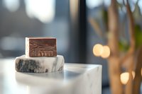 Stacked artisan soaps with natural ingredients on marble pedestal, showcasing handmade skincare products for wellness and beauty retail displays.