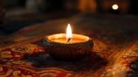 Ornate metal bowl candle with glowing flame on decorative oriental carpet creates atmospheric mood lighting for meditation and spiritual practices.