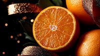 Fresh juicy orange cut in half showing detailed pulp texture and segments on dark background with water drops and bokeh lights, macro food photography.