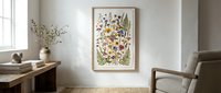 Modern living room interior with botanical wall art featuring colorful wildflowers and ferns in wooden frame, neutral decor and natural lighting.