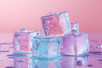 Colorful ice cubes with water droplets on wet surface against pink gradient background for summer drinks and cooling concepts.