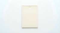 Blank cream notepad with spiral binding on white background, isolated for design projects and mockups.