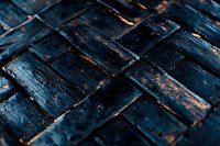 Charred wooden surface with diagonal pattern showing burnt texture and orange glowing embers beneath dark cracked boards. Dramatic lighting creates moody atmosphere.