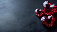 Red heart-shaped gemstones on dark background, romantic crystal jewelry elements with brilliant cut and sparkling facets for luxury Valentine designs.