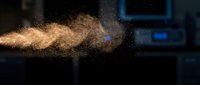 Golden particle explosion with dynamic motion blur against dark blue technology background for digital effects and modern design projects.