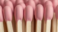 Pink matches arranged in rows showing wooden sticks with pink heads against soft background, macro photography closeup view for fire safety concept.