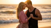 Young couple embracing intimately on beach at golden hour sunset with ocean waves in background creating romantic atmosphere for love and relationship concepts.