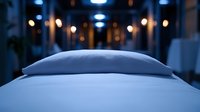 Luxurious hotel bed with crisp white linens and plush pillow in evening light, creating serene atmosphere with soft bokeh lights in background. For hospitality marketing.