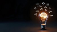 Glowing light bulb with digital technology icons and network symbols on dark background representing innovation and smart solutions for business.