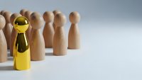 Golden wooden figure stands out among natural wood pieces representing leadership, uniqueness and business success concepts for corporate presentations.