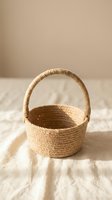 Handwoven jute rope basket with handle on wooden surface against neutral beige background for home decor and storage solutions.