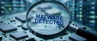 Magnifying glass revealing malware detected text on circuit board with digital code background, representing cybersecurity threat analysis and virus detection.