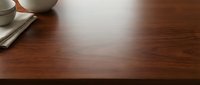Wooden desk surface with ceramic cup and notebook, ideal for workspace, office, and business background designs.