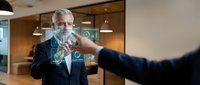 Senior businessman with gray beard touching futuristic holographic interface in modern office environment for technology and innovation concepts.