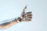 Metallic robotic arm showing thumbs up gesture against light background, representing artificial intelligence and technological advancement in automation.