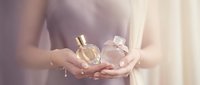 Woman hands holding luxury perfume bottles in soft natural light for beauty and fragrance advertising campaigns.