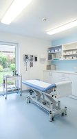 Modern medical examination room with adjustable patient table and equipment cart for healthcare facility interior design and clinical practice.