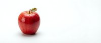 Fresh red apple with green leaf on white background isolated for healthy eating and nutrition concepts.