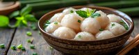 Fresh steamed dumplings with herbs and green onions served in rustic ceramic bowl on wooden table, traditional Asian cuisine panoramic banner.