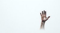 Dramatic raised hand emerging from fog against white background, covered in dark stains and dirt, creating mysterious and haunting atmosphere for horror concepts.