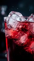 Chilled red cocktail with ice cubes and sparkling bubbles in a glass, dark moody background, close-up macro shot for bar and beverage concepts.