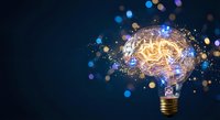 Glowing light bulb with brain inside surrounded by colorful bokeh lights and sparks on dark blue background representing innovation and creative thinking.