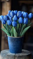 Fresh blue tulips arranged in matching blue textured vase on rustic wooden surface, creating elegant spring floral display with vibrant color coordination.