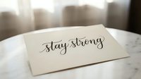 Stay strong handwritten text on cream card with urban skyline background, motivational message for encouragement, resilience and positive affirmation design.