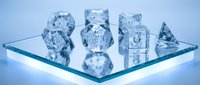 Crystal clear ice cubes arranged on reflective glass surface with cool blue lighting for beverage photography and commercial drink advertising.