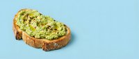 Avocado toast on artisan bread with seeds and herbs on light blue background. Healthy breakfast or snack option for modern lifestyle and nutrition.