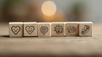 Wooden dice with heart and brain symbols arranged in row on blurred background, representing balance between emotions and logic. Suitable for psychology concepts.