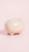 Cute ceramic piggy bank in soft pink speckled finish on pastel background for savings and financial planning concepts.