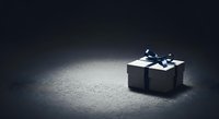 Black gift box with white ribbon bow on textured concrete surface, suitable for holiday marketing, luxury product promotion, and festive greeting card designs.