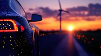 Modern car silhouette against dramatic sunset sky with wind turbine on horizon, rear light detail and water drops on vehicle surface creating atmospheric scene.