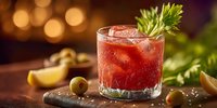 Red cocktail with celery garnish and ice cubes on wooden surface with warm bokeh lights background for bar and restaurant menu design.