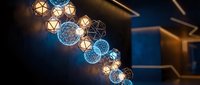 Modern geometric pendant lights with metallic wireframe design creating warm ambient lighting for contemporary interior decor and architectural spaces.