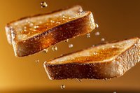 Crispy golden toast slices floating in air with water droplets splashing around them against warm brown background, dramatic food photography macro shot.