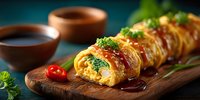 Japanese tamagoyaki rolled omelet with herbs on wooden board, traditional egg dish with soy sauce for breakfast or bento box meal preparation.