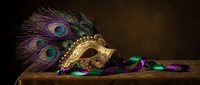 Ornate golden carnival mask with peacock feathers and colorful beads on wooden surface against dark background for Mardi Gras celebration and masquerade party.